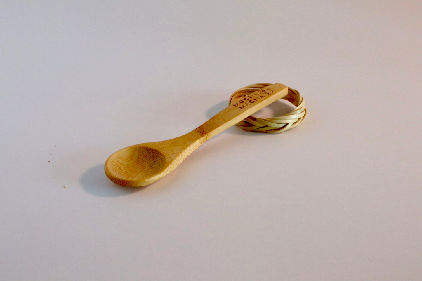 Wooden spoon with engraved text on a light gray background